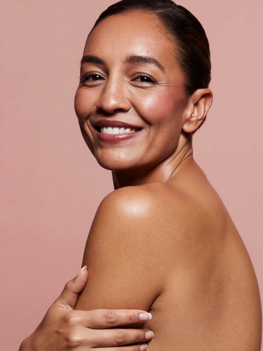 Smiling woman in her 40s with healthy, refreshed skin, a Dr. Rochelin Aesthetic & Wellness patient